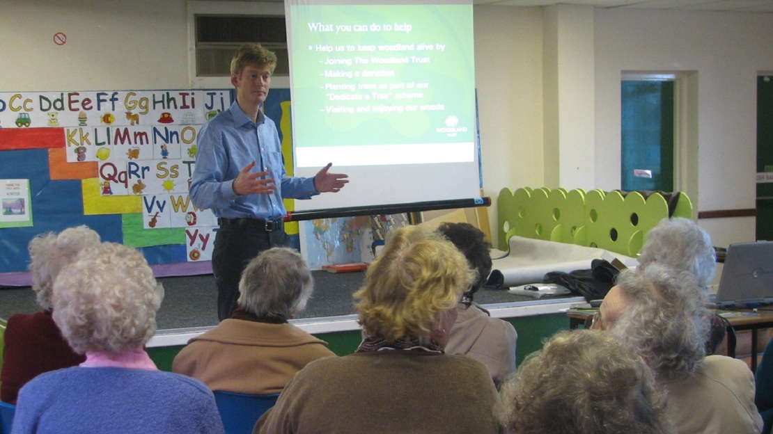 Volunteer speaker presenting to an audience in a community venue