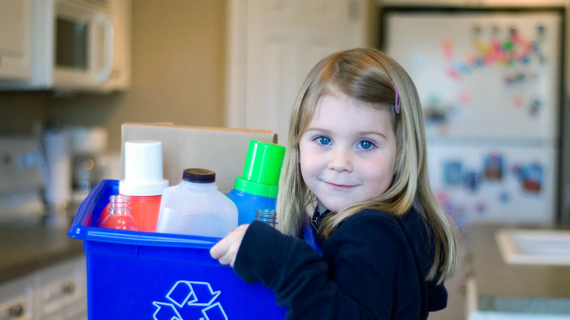 Schoolgirl holding a box of recycling