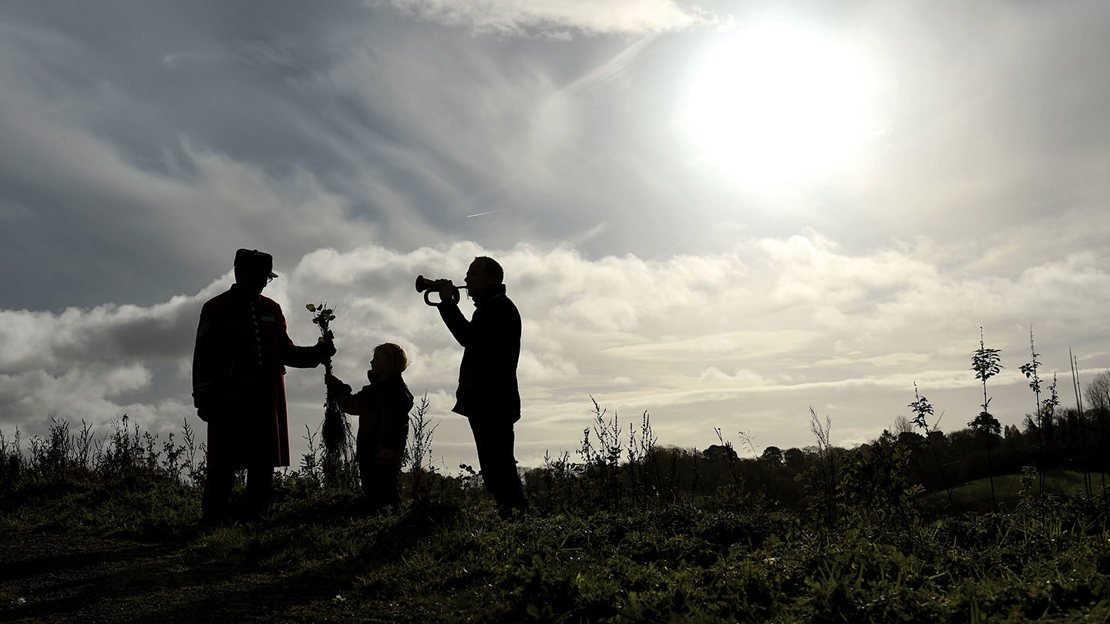 Silhouettes of three people planting a tree at Brackfield