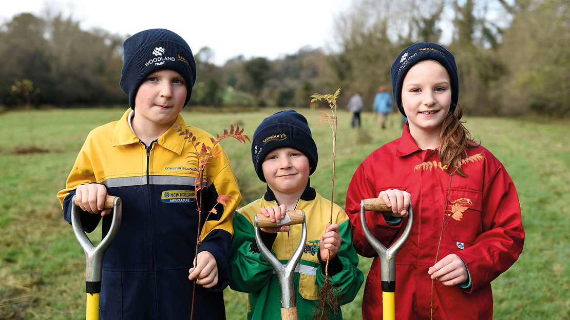 Children with spades and saplings to plant