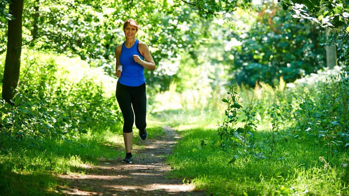 Woman running through woodland