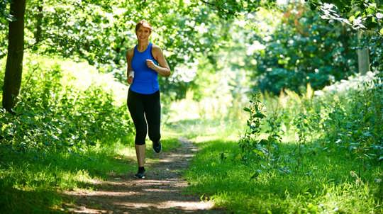 Woman running through woodland