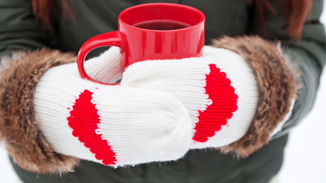 Mittened hands holding onto mug