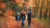 Family walking through a wood in autumn