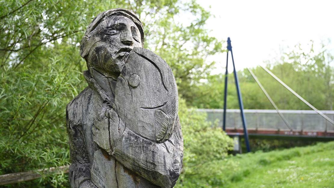 Wooden sculpture of a man holding a fish