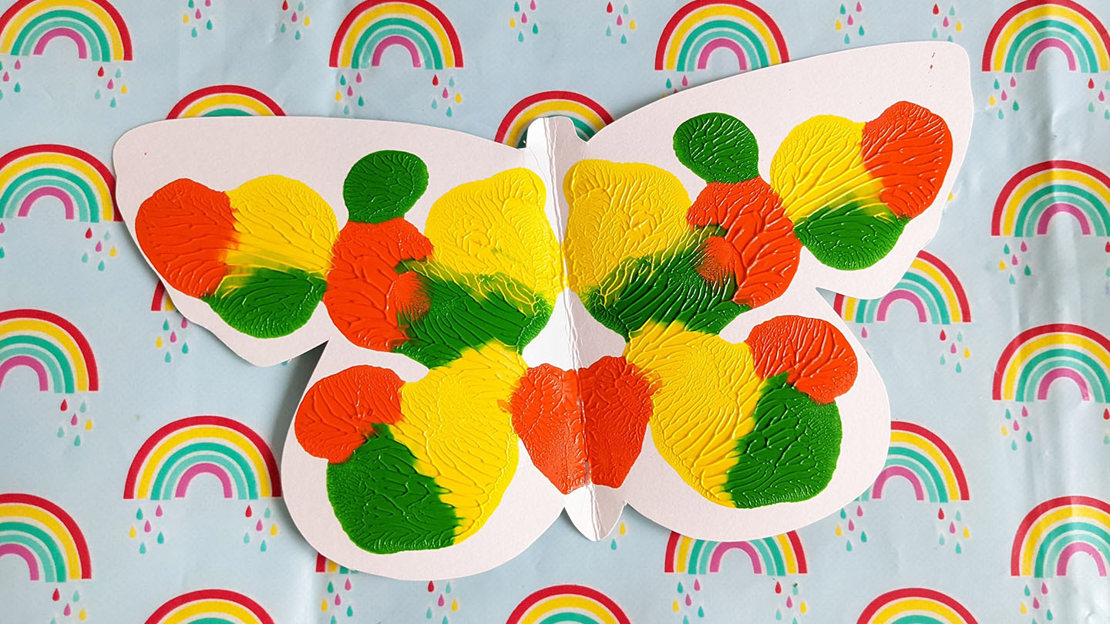 Cheerful butterfly symmetry painting in yellow, orange and green