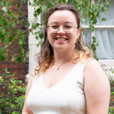 Head and shoulders shot of Woodland Trust trustee, Briony Nesbitt, with a background of tree branches