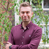 Head and shoulders shot of Woodland Trust trustee, David Saddington, with a background of tree branches