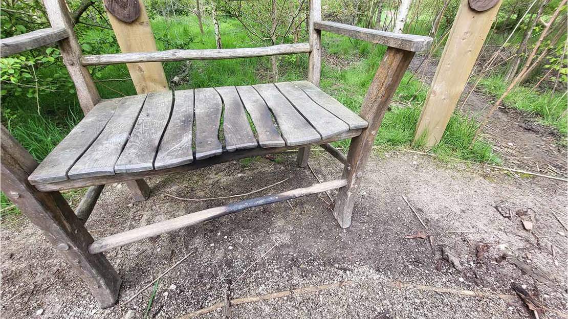 Wooden outdoor classroom bench with burn marks.