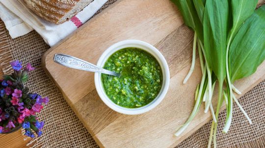 Wild garlic pesto in a bowl on wooden chopping board