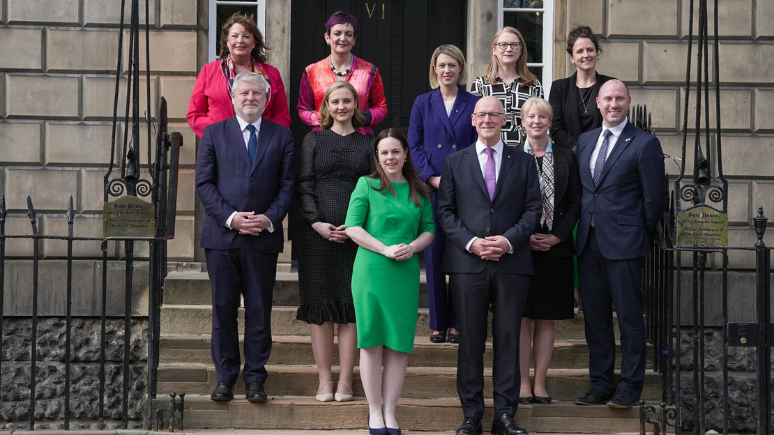 The Scottish Government cabinet standing in group on steps outside building.